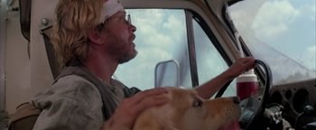 Movie still from “Twister” (1996), directed by Jan de Bont – A man driving a car with a dog in his lap; Close Up shot, Low angle