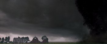 Movie still from “Twister” (1996), directed by Jan de Bont – Two barns in the middle of a field under a cloudy sky; Extreme Wide shot, Low angle