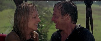 Movie still from “Twister” (1996), directed by Jan de Bont – A man and a woman smiling at each other in the rain; Close Up shot, Low angle