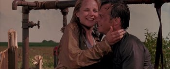 Movie still from “Twister” (1996), directed by Jan de Bont – A man and a woman are hugging in the rain; Medium shot, Low angle