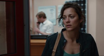 Movie still from “Two Days, One Night” (2014), directed by Jean-Pierre Dardenne – A woman standing in front of a man in front of a counter; Close Up shot, Over the shoulder angle