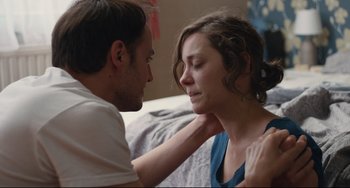 Movie still from “Two Days, One Night” (2014), directed by Jean-Pierre Dardenne – A man and a woman sitting on a bed together; Close Up shot, Over the shoulder angle