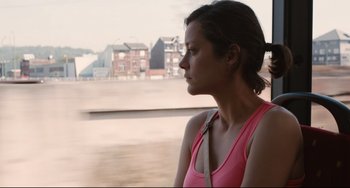 Movie still from “Two Days, One Night” (2014), directed by Jean-Pierre Dardenne – A woman in a pink shirt looking out of a window; Close Up shot, High angle