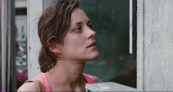 Movie still from “Two Days, One Night” (2014), directed by Jean-Pierre Dardenne – A person looking up at something; Close Up shot, Over the shoulder angle