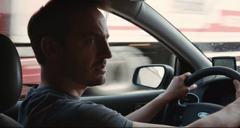 Movie still from “Two Days, One Night” (2014), directed by Jean-Pierre Dardenne – A person in a car on the road; Close Up shot, Over the shoulder angle