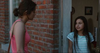 Movie still from “Two Days, One Night” (2014), directed by Jean-Pierre Dardenne – Two young women standing next to a brick wall; Medium shot, Over the shoulder angle