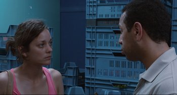 Movie still from “Two Days, One Night” (2014), directed by Jean-Pierre Dardenne – A man and a woman are talking in a room; Close Up shot, Over the shoulder angle