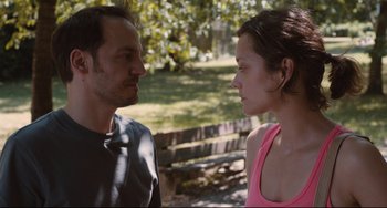 Movie still from “Two Days, One Night” (2014), directed by Jean-Pierre Dardenne – A man and a woman face to face in a wooded area; Close Up shot, Over the shoulder angle