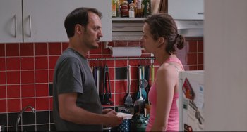 Movie still from “Two Days, One Night” (2014), directed by Jean-Pierre Dardenne – A man and a woman in a kitchen talking to each other; Medium shot, Over the shoulder angle
