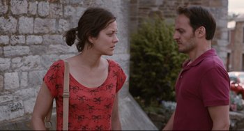 Movie still from “Two Days, One Night” (2014), directed by Jean-Pierre Dardenne – A man and a woman standing next to each other; Medium shot, Low angle