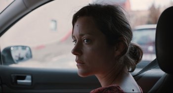 Movie still from “Two Days, One Night” (2014), directed by Jean-Pierre Dardenne – A person sitting in a car; Close Up shot, Over the shoulder angle