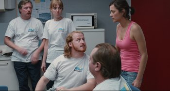 Movie still from “Two Days, One Night” (2014), directed by Jean-Pierre Dardenne – A group of young people gathered around a man with long red hair; Medium shot, Over the shoulder angle