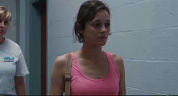 Movie still from “Two Days, One Night” (2014), directed by Jean-Pierre Dardenne – A woman in a pink tank top with a brown purse; Close Up shot, Over the shoulder angle