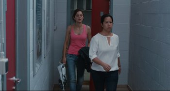 Movie still from “Two Days, One Night” (2014), directed by Jean-Pierre Dardenne – Two women walking down the hall way of a building; Medium shot, Over the shoulder angle