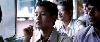 Movie still from “Udaan” (2010), directed by Vikramaditya Motwane – A man sitting next to another man on a train; Close Up shot, Low angle