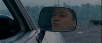 Movie still from “Udaan” (2010), directed by Vikramaditya Motwane – A man's reflection in the side view mirror of a car; Close Up shot, Low angle
