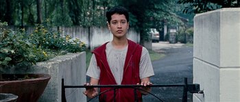 Movie still from “Udaan” (2010), directed by Vikramaditya Motwane – A young man standing behind a metal fence; Medium shot, Low angle