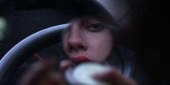 Movie still from “Under the Skin” (2013), directed by Jonathan Glazer – A woman in a car looking at the camera; Extreme Close Up shot, Overhead angle