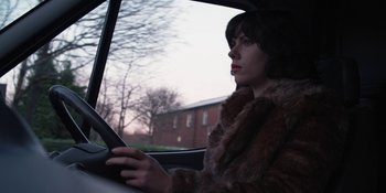 Movie still from “Under the Skin” (2013), directed by Jonathan Glazer – A woman sitting in the drivers seat of a car; Close Up shot, Low angle