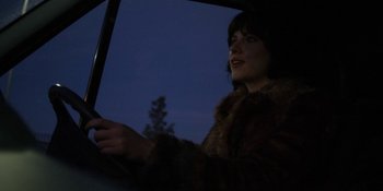 Movie still from “Under the Skin” (2013), directed by Jonathan Glazer – A woman in a fur coat driving a car at night; Close Up shot, Low angle