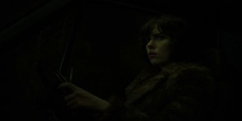 Movie still from “Under the Skin” (2013), directed by Jonathan Glazer – A woman sitting in a car holding a steering wheel; Close Up shot, Low angle