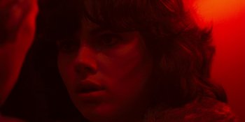 Movie still from “Under the Skin” (2013), directed by Jonathan Glazer – A woman's face in red light; Close Up shot, High angle