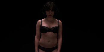 Movie still from “Under the Skin” (2013), directed by Jonathan Glazer – A woman in a black bra and black panties; Medium shot, Overhead angle
