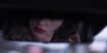 Movie still from “Under the Skin” (2013), directed by Jonathan Glazer – A person's face in a dark room; Extreme Close Up shot, Over the shoulder angle