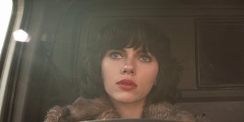 Movie still from “Under the Skin” (2013), directed by Jonathan Glazer – A person in a car looking at the camera; Close Up shot, Low angle
