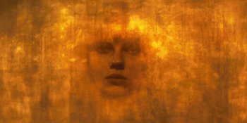 Movie still from “Under the Skin” (2013), directed by Jonathan Glazer – A blurry image of a woman's face in a yellow room; Extreme Close Up shot, Overhead angle