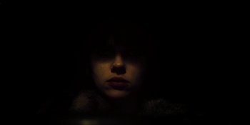 Movie still from “Under the Skin” (2013), directed by Jonathan Glazer – A woman in a fur coat is in the dark; Close Up shot, Low angle