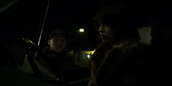 Movie still from “Under the Skin” (2013), directed by Jonathan Glazer – A man and a woman in a car at night; Medium shot, Over the shoulder angle