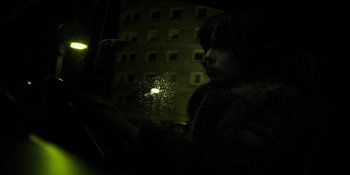 Movie still from “Under the Skin” (2013), directed by Jonathan Glazer – A person looking out of a car window at night; Medium shot, Low angle