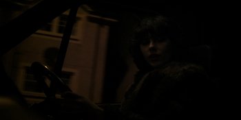 Movie still from “Under the Skin” (2013), directed by Jonathan Glazer – A woman is standing in a dark room; Close Up shot, Low angle