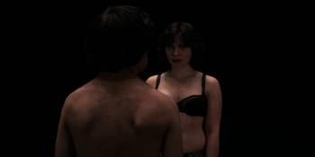 Movie still from “Under the Skin” (2013), directed by Jonathan Glazer – A man and a woman in front of a bathroom mirror; Medium shot, Over the shoulder angle
