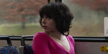 Movie still from “Under the Skin” (2013), directed by Jonathan Glazer – A woman sitting on a bus looking out the window; Close Up shot, Over the shoulder angle