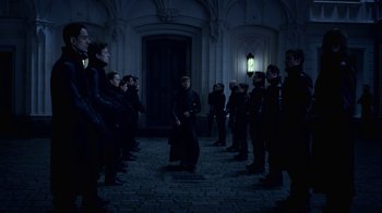 Movie still from “Underworld: Blood Wars” (2016), directed by Anna Foerster – A group of people standing in front of a building at night; Wide shot, High angle