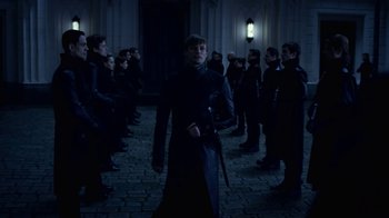 Movie still from “Underworld: Blood Wars” (2016), directed by Anna Foerster – A group of people standing around a building at night; Wide shot, Over the shoulder angle