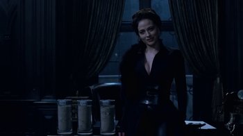 Movie still from “Underworld: Blood Wars” (2016), directed by Anna Foerster – A woman standing in front of a table with drinks; Medium shot, Over the shoulder angle
