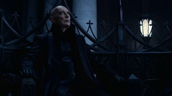 Movie still from “Underworld: Blood Wars” (2016), directed by Anna Foerster – An old man wearing a black coat and a black jacket; Medium shot, Low angle