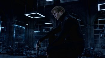Movie still from “Underworld: Blood Wars” (2016), directed by Anna Foerster – A man holding a gun while sitting on the ground; Medium shot, Low angle