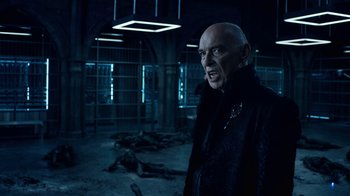 Movie still from “Underworld: Blood Wars” (2016), directed by Anna Foerster – A man in a black jacket standing next to a cage; Medium shot, Over the shoulder angle