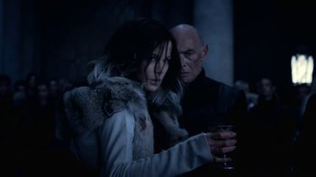 Movie still from “Underworld: Blood Wars” (2016), directed by Anna Foerster – A man and a woman standing next to each other holding a glass; Medium shot, Over the shoulder angle
