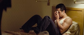 Movie still from “United 93” (2006), directed by Paul Greengrass – A man sitting on a bed while holding a cell phone to his ear; Medium shot, High angle
