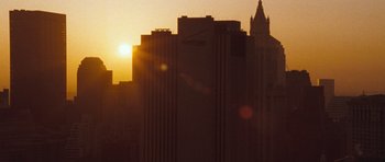 Movie still from “United 93” (2006), directed by Paul Greengrass – The sun is setting behind a large building; Extreme Wide shot, Low angle