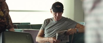 Movie still from “United 93” (2006), directed by Paul Greengrass – An older man reading a newspaper while sitting on a bench; Close Up shot, Low angle
