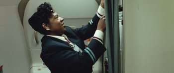 Movie still from “United 93” (2006), directed by Paul Greengrass – A man in a uniform is fixing a piece of luggage; Medium shot, Low angle