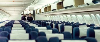 Movie still from “United 93” (2006), directed by Paul Greengrass – A man standing on a plane looking out of the window; Wide shot, High angle