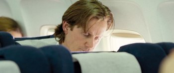 Movie still from “United 93” (2006), directed by Paul Greengrass – A man sitting on a plane looking down at his phone; Close Up shot, Low angle