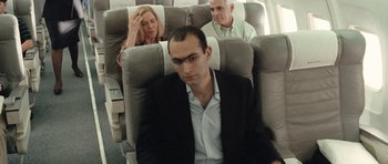 Movie still from “United 93” (2006), directed by Paul Greengrass – A man sitting on a plane next to two other people; Medium shot, High angle